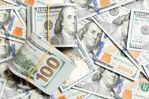 Many Stack of 100 dollar bills on dollars background top wiev with copy space photo