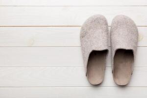 Warm winter women woolen slippers on the floor. Copy space for text photo