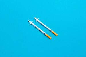 Top view of two insulin syringe at colorful background with copy space. High level of glucose concept photo