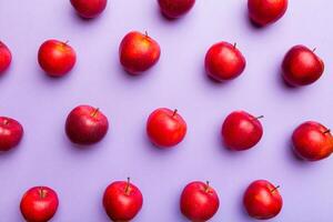 Many red apples on colored background, top view. Autumn pattern with fresh apple above view photo