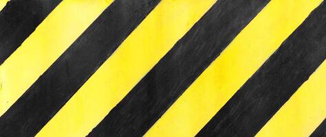 Safety stripes on construction site, Black and yellow Under construction sign over a grunge texture, top view photo