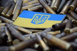 Ukrainian national flag with the coat of arms on the background of military camouflage surrounded by shells. photo