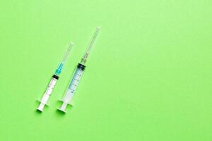 Top view of syringes in a row for medical injection on colorful background with copy space. Health and vaccination concept photo