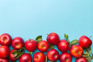 Many red apples on colored background, top view. Autumn pattern with fresh apple above view with copy space for design or text photo