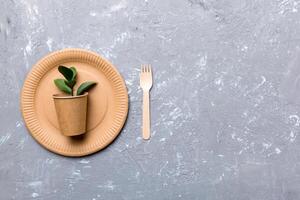 set of empty reusable disposable eco-friendly plates, cups, utensils on light white colored table background. top view. Biodegradable craft dishes. Recycling concept. Close-up photo