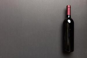 uno botella de rojo vino en de colores mesa. plano poner, parte superior ver con Copiar espacio foto