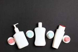 Set of travel size cosmetic bottles on colored background. Flat lay of cream jars. Top view of bodycare style concept photo