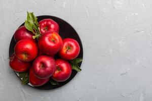 Many red apples on cement background, top view. Autumn pattern with fresh apple above view photo