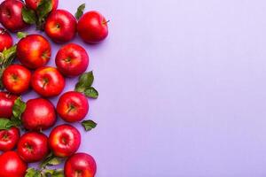 Many red apples on colored background, top view. Autumn pattern with fresh apple above view with copy space for design or text photo