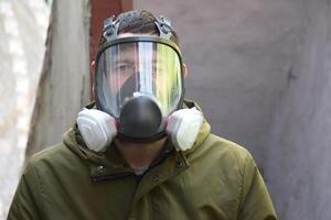 A young guy in a respirator in a bomb shelter. photo