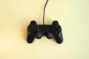 One joystick gaming controller on yellow background. photo