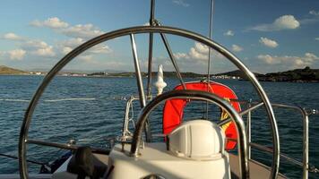 Panoramic video of the mountains through the helm, handrails and sail ropes from the yacht deck anchored in the bay