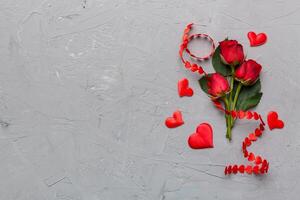 Valentine day composition with rose flower and red heart on table. Top view, flat lay, copy space Holiday concept photo