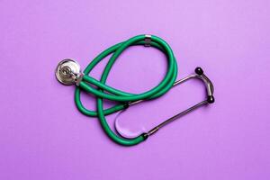 Top view of green stethoscope on colorful background. Medical diagnosis tool concept photo