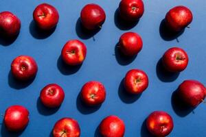 Many red apples on colored background, top view. Autumn pattern with fresh apple above view photo