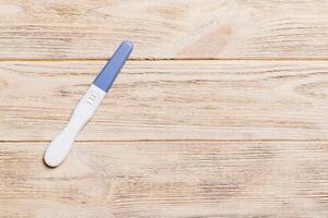 Colored Pregnancy test on wooden background, top view with copy space photo