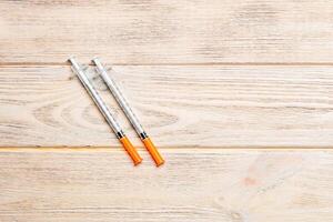 Top view of insulin syringe prepared for injection at wooden background. Diabetes concept with copy space photo