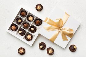 White box with chocolates candies and golden tape. top view with copy space photo