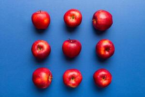 Many red apples on colored background, top view. Autumn pattern with fresh apple above view photo