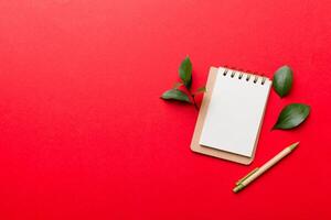 eco-friendly Empty notebook with pen and green leaf on Colored background for note photo