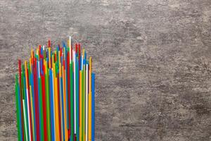 Heap of colorful plastic drinking straws on Colored background, flat lay. Copy Space for text photo