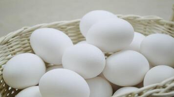 Raw eggs in a rotating basket. White chicken eggs in turn top view video