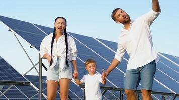 Lycklig familj gående nära sol- paneler, grön levande begrepp video