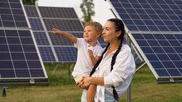 Young mother with her little son by solar panels. Mothers day video