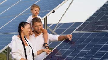 content famille près solaire panneaux. père en présentant à famille moderne énergie Ressource video