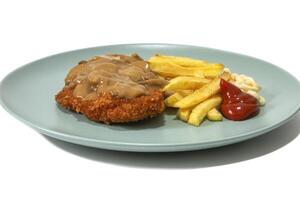 Jaegerschnitzel with French fries, ketchup and mayonaise, served on a turquoise plate. Isolated on white background. photo