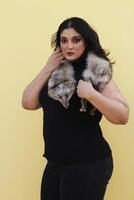 a woman holding a small furry animal in her arms photo