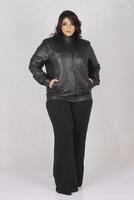 un mujer en un negro cuero chaqueta y negro pantalones foto
