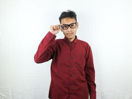 Portrait asian man wearing a red shirt smiles while holding glasses photo