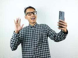 Portrait of asian man holding mobile phone with face expression smiling at camera.Portrait of asian man holding mobile phone with face expression smiling at camera. photo