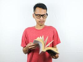 portrait of asian man holding book with reading focused expression. photo