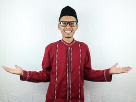 Asian muslim man raised arms and looking at camera with doubtful face isolated on white background photo