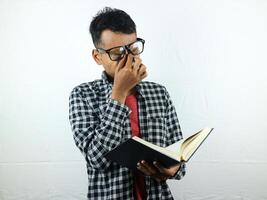 Portrait of Asian student holding book with thinking face expression photo