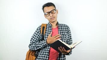 Portrait of Asian student holding book with thinking face expression photo