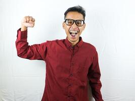 Handsome Man in Glasses Celebrating Success With Clenching Fist and Happy Face Expression. photo