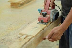 Close up of sanding a wood with orbital sander at workshop photo