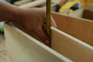 carpintero trabajando en taller. carpintero medición utilizando lápiz y gobernante. foto