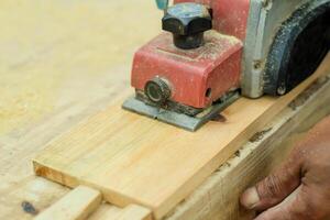 Close up of sanding a wood with orbital sander at workshop photo