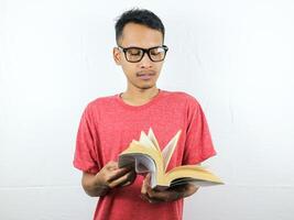 retrato de asiático hombre participación libro con leyendo enfocado expresión. foto