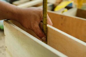 Carpenter working in workshop. carpenter measuring using pencil and ruler. photo