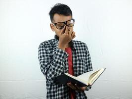 Portrait of Asian student holding book with thinking face expression photo