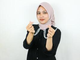 Portait smiling young muslim woman showing heart gesture with both hands. photo