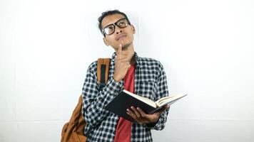 Portrait of Asian student holding book with thinking face expression photo