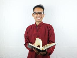 hermoso asiático negocio hombre sonriente y participación y leyendo libro en mano foto