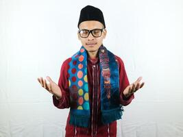 Religious asian muslim man in traditional dress using prayer beads isolated on white background photo