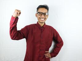 Handsome Man in Glasses Celebrating Success With Clenching Fist and Happy Face Expression. photo